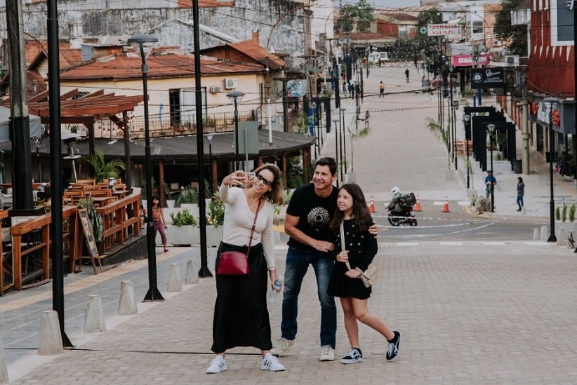 Família faz selfie na Avenida Brasil, tendo como cenário de fundo a esquina das 