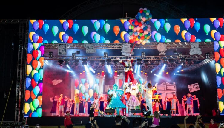 Após sobrevoar a plateia, Papai Noel pousou no palco pendurado em balões. Foto: Marcos Labanca