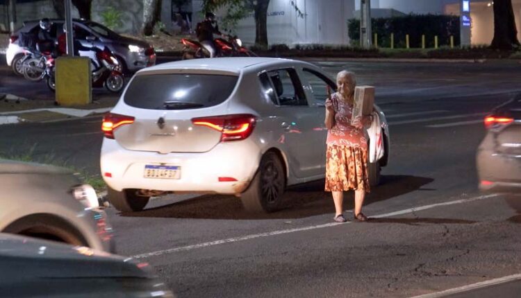 Entre os carros, sinal aberto e fechado, Dona Olinda retrata uma parcela de brasileiros idosos, que dependem de subempregos