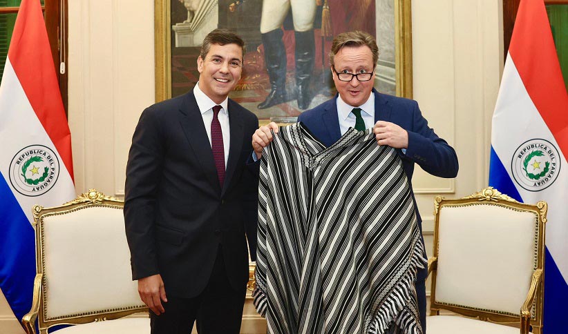 Ministro britânico foi presenteado com um poncho para'i, vestimenta paraguaia recentemente incluída na lista de patrimônio imaterial da Unesco. Foto: Gentileza/Presidência do Paraguai